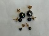 three pairs of black pearl earrings on a white background