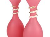 two pink vases with gold designs on them