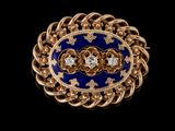 un gros plan sur une broche bleue et dorée sertie de diamants