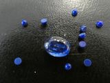 un gros plan d'un objet en verre bleu posé sur une surface noire