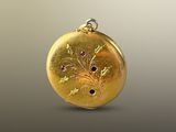 yellow gold locke with pink sapphires on a gray background