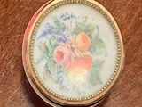 a small box with a painting on it on a table