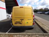a yellow van parked in a parking lot next to a building