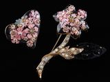 deux fleurs roses et une broche en forme de cœur sur fond noir