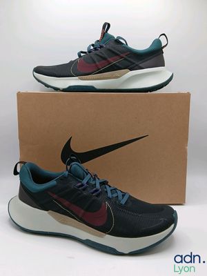 a pair of black and purple sneakers with a box on a white background