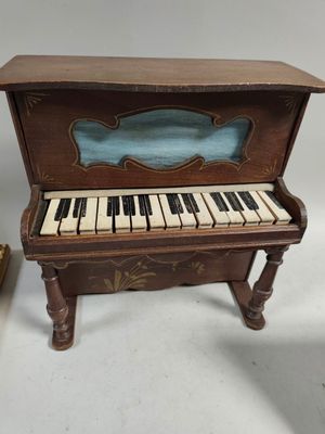 un piano miniature posé à côté d'un livre