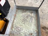 a small metal box with holes in it on the ground