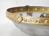 a gold and silver bowl with a handle on it