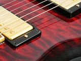 a close up of a red electric guitar with a black neck