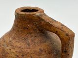 a brown vase that is sitting on a white surface