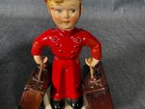 une figurine représentant un garçon avec des valises posées sur une table