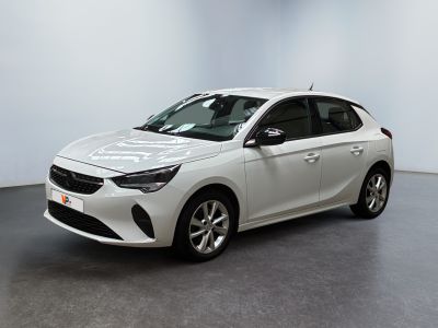 Une voiture blanche est garée dans une pièce au sol gris.