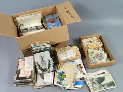 a cardboard box filled with old books and postcards