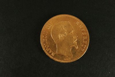 gros plan d'une pièce d'or sur une surface noire