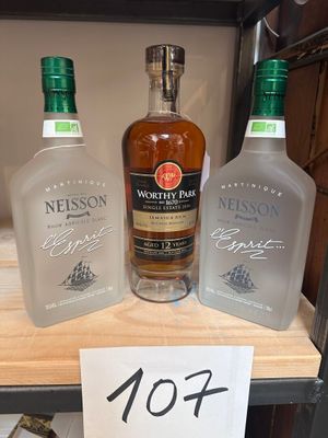 Trois bouteilles d'alcool sont posées sur une étagère, accompagnées d'une étiquette de prix.
