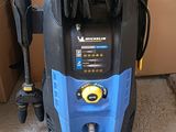 a blue and black high pressurer on the floor next to a brown box