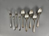 six silverplated spoons and six forks arranged in a row