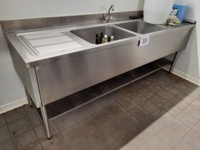 a stainless steel sink in the corner of a kitchen