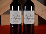 two bottles of wine sitting on a table next to each other