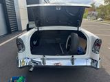 a white car with its trunk open in a parking lot