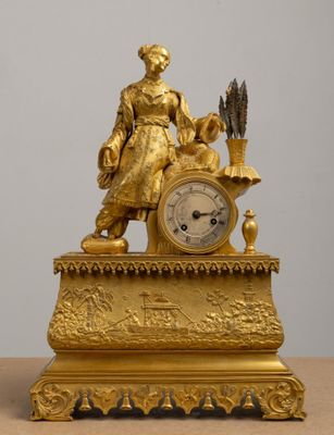 a gold clock sitting on top of a wooden table