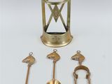 an image of a collection of brass objects including a clock, a hammer, and other items