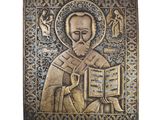 une plaque métallique sur laquelle figure l'image d'un homme tenant un livre