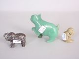 three small figurines of animals on a white surface