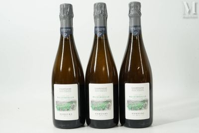 trois bouteilles de vin posées sur une table blanche