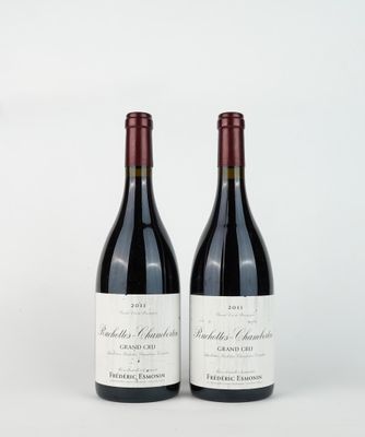 two bottles of red wine sitting next to each other on a white surface