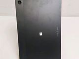 the back of a black laptop computer sitting on top of a white table