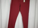 a pair of red jeans hanging on a white curtain