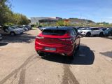 the rear end of a red car parked in a parking lot