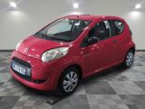 la petite voiture rouge est garée sur un sol en damier