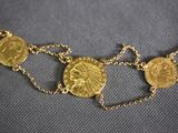 a close up of a gold coin necklace on a blue background