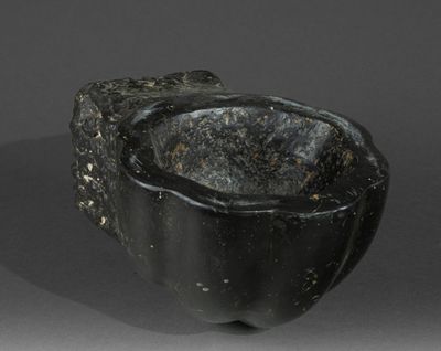 a black stone bowl sitting on top of a table