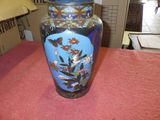 a blue vase sitting on a table with a pink table cloth