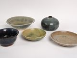 four bowls and a bowl are sitting on a white surface