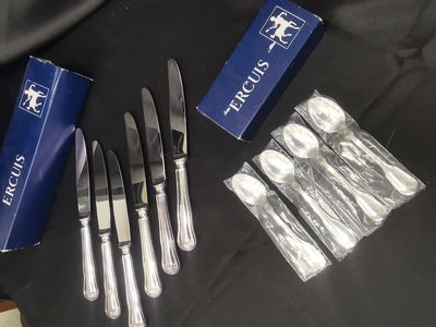 four forks, a knife, and a box of silverware on a table