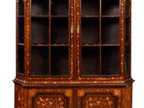 an antique wooden cabinet with glass doors and carvings on the front