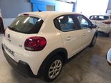 the rear end of a white car parked in a garage
