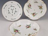 deux assiettes ornées de motifs floraux et de bordures dorées