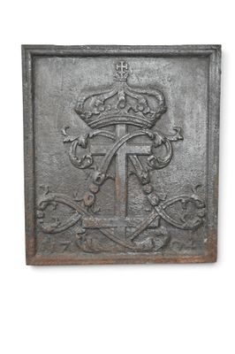 une vieille plaque métallique sur laquelle figurent une couronne et une croix