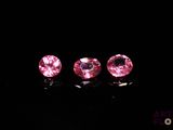 a pair of pink sapphires on a black surface