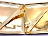 a gold case with a pair of scissors inside of it