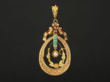un pendentif en or et émeraude orné d'un oiseau
