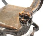 a wooden chair with a lion head on the back of it