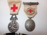two medals and a medal are sitting on a white surface