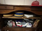 a wooden cabinet with plates and bowls on top of it