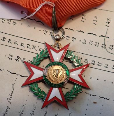 une médaille posée sur un ruban rouge, elle-même posée sur un morceau de papier